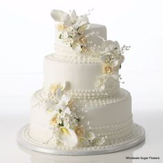 a wedding cake with white flowers and pearls