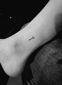 a small cross tattoo on the ankle