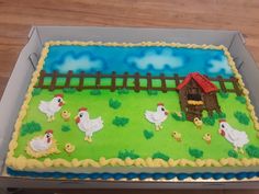 a sheet cake decorated with farm animals and chickens in a box on a wooden table