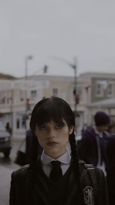 a woman with braids standing in the middle of a street