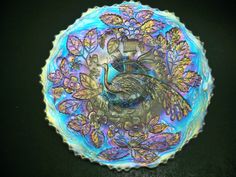 a decorative glass plate with a peacock on it