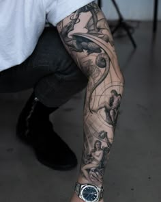 a man's arm with tattoos on it and an image of people in the background