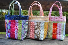 three bags sitting on top of a wooden bench