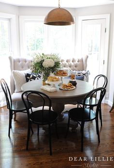 a dining room table and chairs with food on it