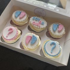 a box filled with cupcakes covered in frosting and decorated like baby shoes