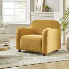 a living room with a yellow chair and white couch in the corner, next to a coffee table