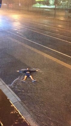 a person laying on the ground in the rain