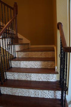 a set of wooden stairs with wrought iron handrails