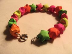 a bracelet made out of different colored pieces of paper with a metal hook on the end