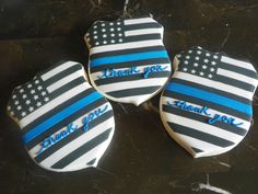 three decorated cookies with the american flag and thank you written in blue frosting on them