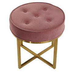 a pink ottoman with gold legs and a round cushion on it's backrest