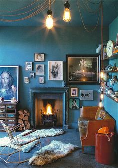 a living room with blue walls and pictures on the wall, including a fire place