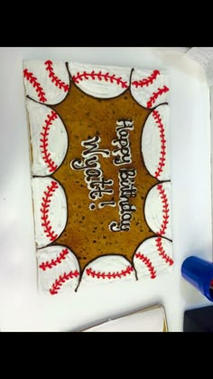 there is a cake with baseballs on it and the words happy birthday written in white frosting