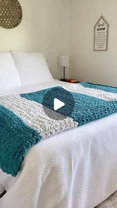 a bed with white and blue blankets on it