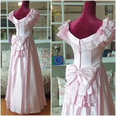 the dress is made up of pink satin and has ruffled trims on it