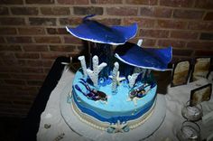 there is a cake with blue frosting and decorations on the top, along with other items