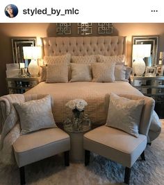 a large bed sitting in a bedroom next to two chairs