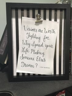 a piece of paper with writing on it in a black frame next to other items