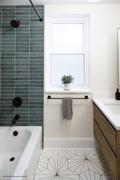 a white bath tub sitting next to a window in a bathroom under a skylight