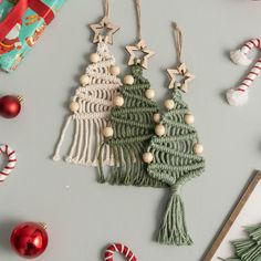 christmas tree ornaments and candy canes on a gray surface with other holiday decorations around them