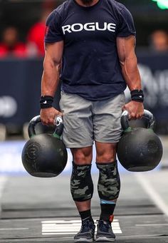 a man holding two kettles while wearing knee pads