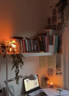 a laptop computer sitting on top of a desk next to a lamp and bookshelf