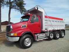 a red and white dump truck parked in a parking lot