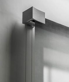 a wall mounted shower head with a chain attached to it's side in a bathroom