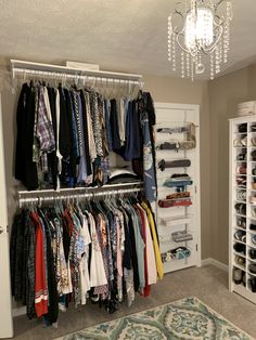 a closet filled with clothes and shoes next to a chandelier hanging from the ceiling