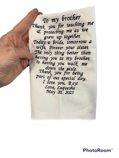 a hand holding up a piece of paper with writing on it