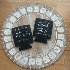 two black coasters sitting on top of a wooden table next to each other, with the words i'll drink and do that written on them