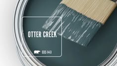 a paint can with a brush in it and the words otter creek painted on it