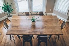 a dining room table with chairs and a potted plant on top of the table