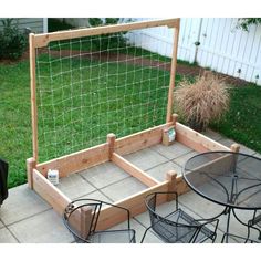 a small backyard area with chairs, table and soccer goal