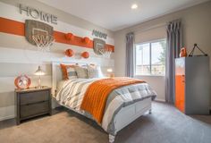 a bedroom decorated in orange and gray with basketballs on the wall