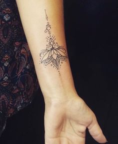 a woman's arm with a small tattoo on the left side of her wrist