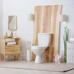 a white toilet sitting in a bathroom next to a wooden dresser and mirror on the wall