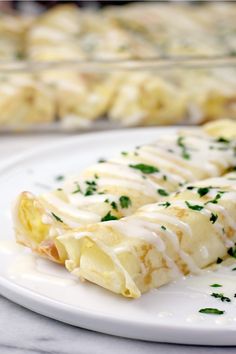 an enchilada is sitting on a plate next to a tray of food