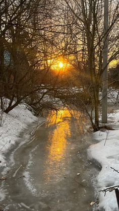 the sun is setting over an icy river