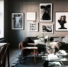 a living room filled with furniture and pictures on the wall above it's coffee table