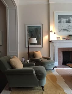 a living room filled with furniture and a fire place under a painting on the wall