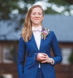 a woman in a blue suit holding an apple