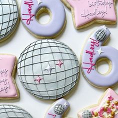 decorated birthday cookies arranged on top of each other in pink, purple and silver colors