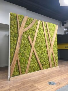 a moss covered wall in an office with wooden slats on the sides and roads painted on it