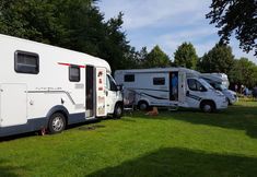 two campers parked in the grass next to each other