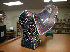 a sculpture made out of colored circles on top of a wooden table in a library