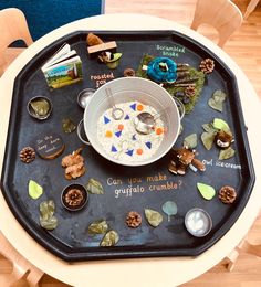 a bowl of food on top of a black tray with writing on it and other items around it