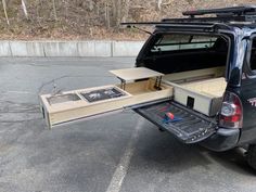 the back end of a black truck with an open hatchback and drawers on it