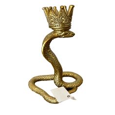 a gold snake with a crown on it's head and a tag in its mouth