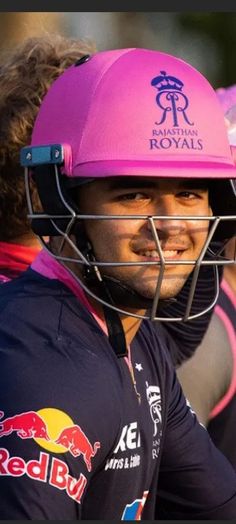 a man wearing a pink helmet and holding a baseball bat